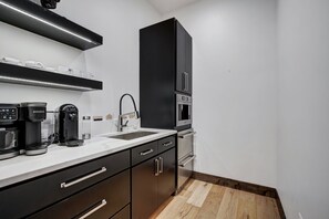 A modern kitchen with a coffee maker, kettle, and microwave. - NEW Trailblazer Lodge, the Ultimate Family Destination (Breckenridge)