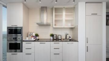 A modern kitchen with white cabinetry, stainless steel appliances, and a granite countertop.