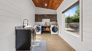 A laundry room with a washing machine, dryer, and a sink. - Broken Bow Cabin w/ Hot Tub, Creek & 3 Acres (Broken Bow)
