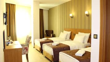 A hotel room with two beds, a desk, and a chair.