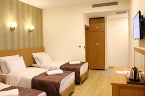 A hotel room with two beds, a desk, a television, and a wardrobe. - Realist Hotel (Istanbul)
