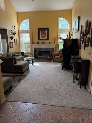 A living room with a fireplace, sofas, a coffee table, and a TV stand.