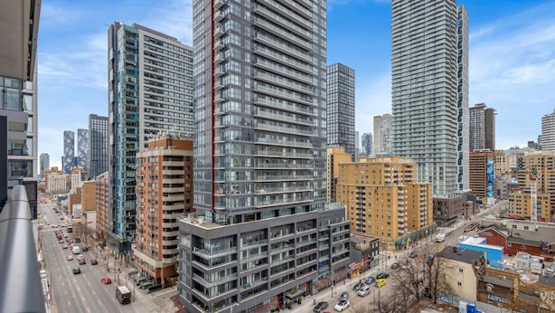 A high-rise building with multiple floors, large windows, and a modern architectural design. - Downtown Retreat Near Union Station (Toronto)