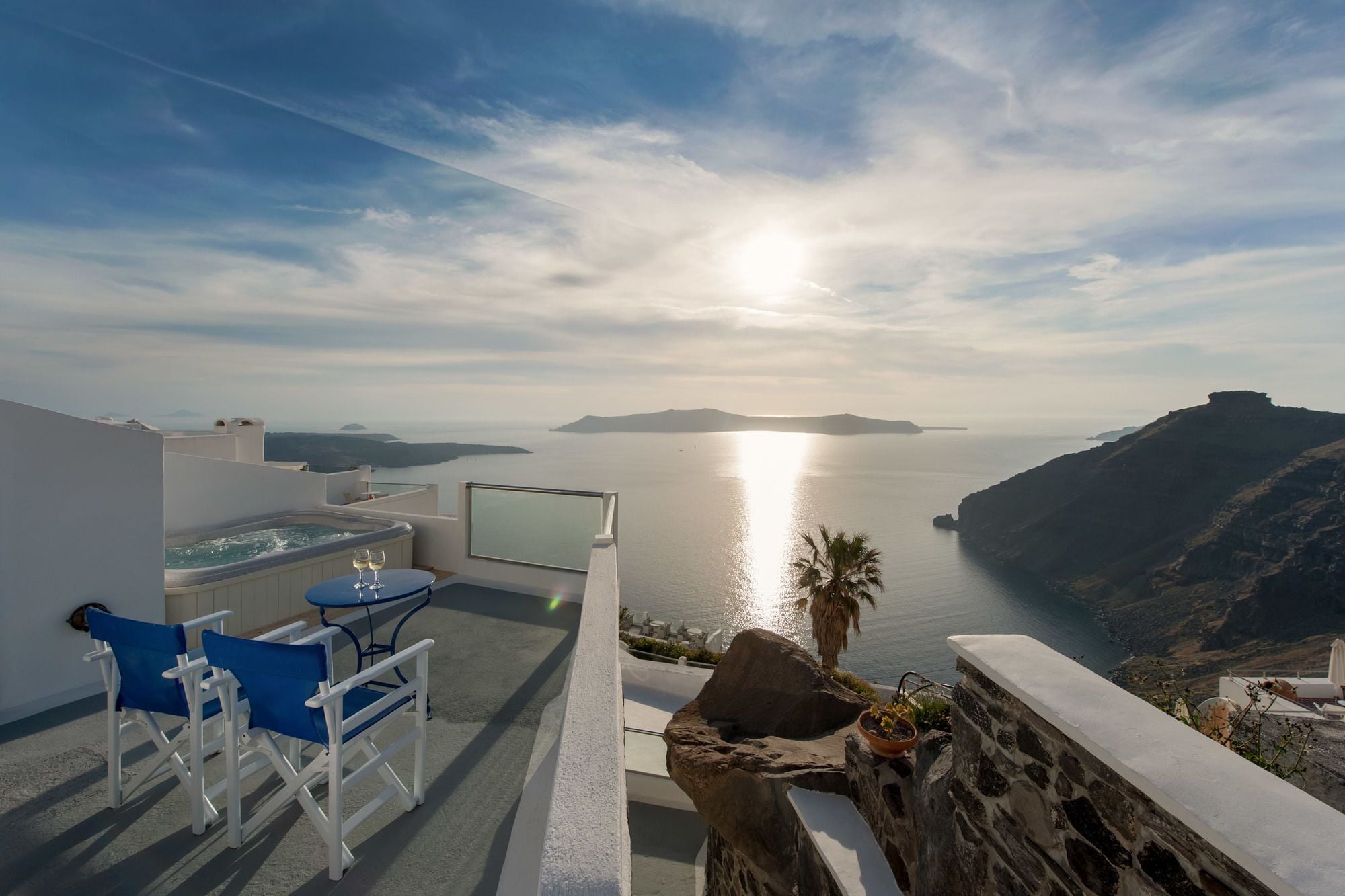 Una terraza con vistas al mar, un jacuzzi y una mesa con sillas.