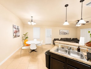 Cocina compacta con comedor, horno empotrado y ventilador de techo.
