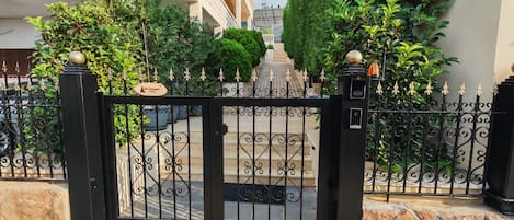 Una entrada con portón y un camino de piedra que lleva a un edificio.