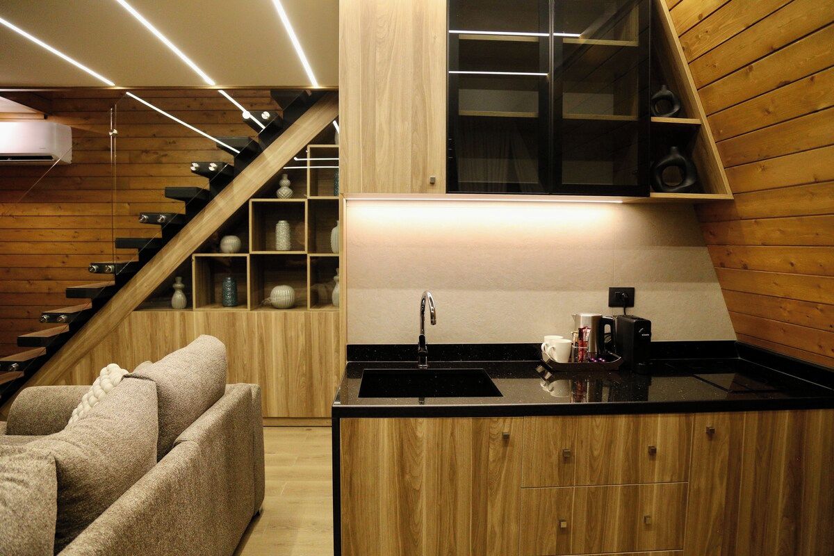 A modern kitchen with a black countertop, wooden cabinets, and a built-in sink.