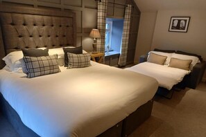 A hotel room with a large bed, a smaller bed, a desk, and a chair. - The Fenwick Arms (Lancaster)