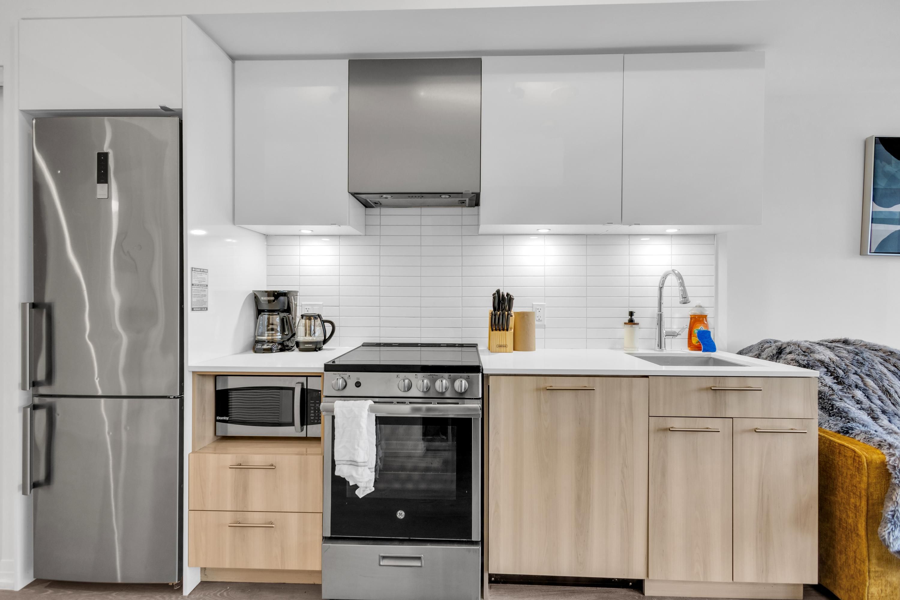 A modern kitchen with stainless steel appliances, a built-in oven, and a microwave.