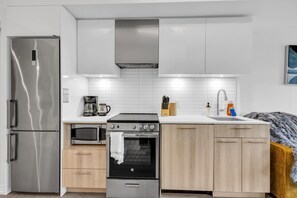 Uma cozinha moderna com eletrodomésticos de aço inoxidável, forno embutido e micro-ondas.