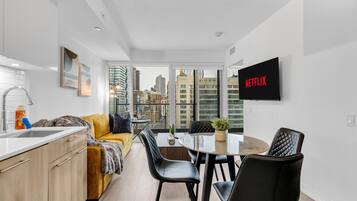 Un apartamento moderno con cocina, comedor y un amplio ventanal con vista a la ciudad.