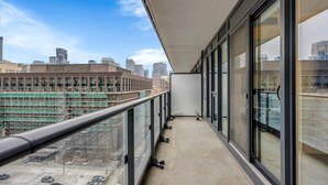 A balcony with a city view, large windows, and a concrete floor. - Downtown Suites Near Eaton Centre (Toronto)