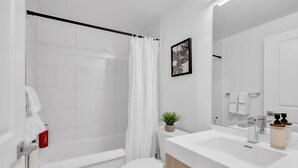 A modern bathroom with a shower, toilet, and sink. - Downtown Suites Near Eaton Centre (Toronto)