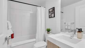 A modern bathroom with a shower, toilet, and sink.