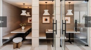 Un intérieur moderne avec des cloisons en verre, des luminaires suspendus et un mobilier minimaliste.
