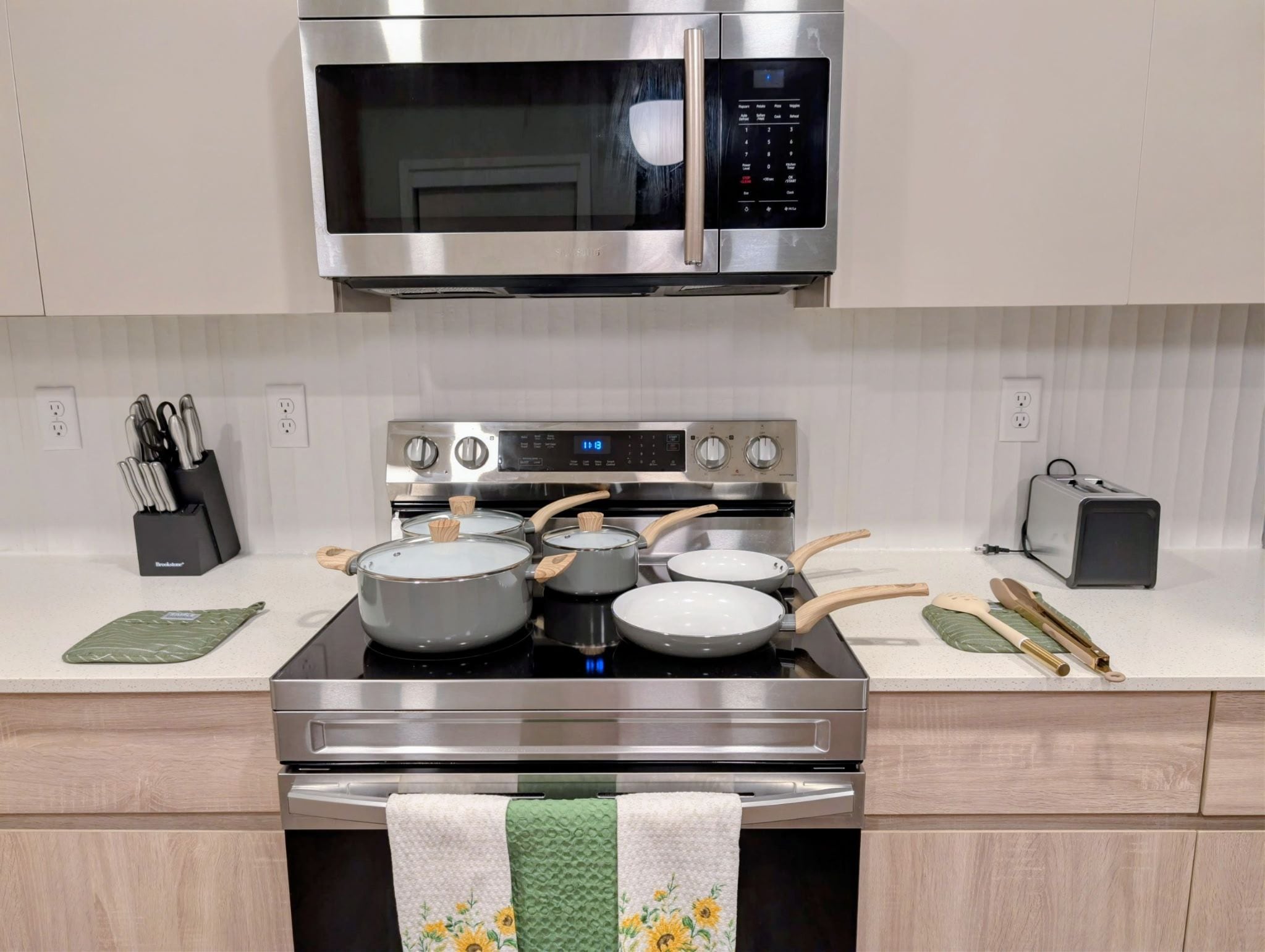 Een moderne keuken met een roestvrijstalen fornuis, oven en magnetron.