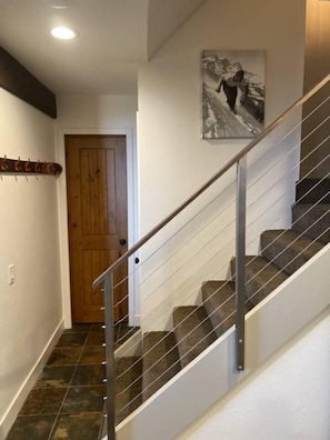 A staircase with a metal handrail and carpeted steps leading to a wooden door. - Sierra Sky Retreat, Sleeps 6, Mountain Views, Pool/Hot Tubs, Near Canyon Lodge (Mammoth Lakes)