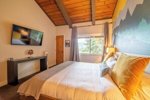 A bedroom with a bed, a TV mounted on the wall, a desk, and a window with curtains. - Sierra Sky Retreat, Sleeps 6, Mountain Views, Pool/Hot Tubs, Near Canyon Lodge (Mammoth Lakes)