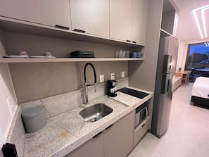 A modern kitchen with a built-in dishwasher, a coffee maker, and a refrigerator. - Sole e Mare Flat on Muro Alto beach. (N. Sra. do Ó)