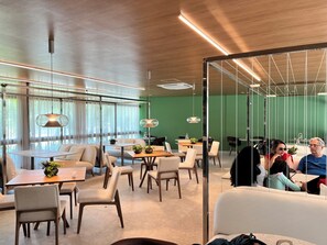 A modern dining area with tables, chairs, and hanging pendant lights. - Sole e Mare Flat on Muro Alto beach. (N. Sra. do Ó)