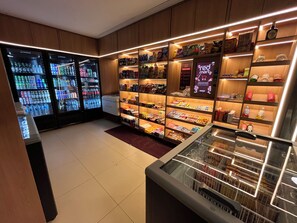 A well-lit convenience store with shelves stocked with snacks, beverages, and household items. - Sole e Mare Flat on Muro Alto beach. (N. Sra. do Ó)