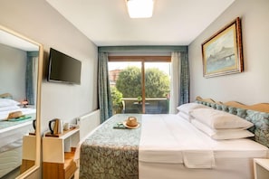 A hotel room with a bed, a television, a painting, and a view of the outdoors. - Elite Aparts By MK (Istanbul)