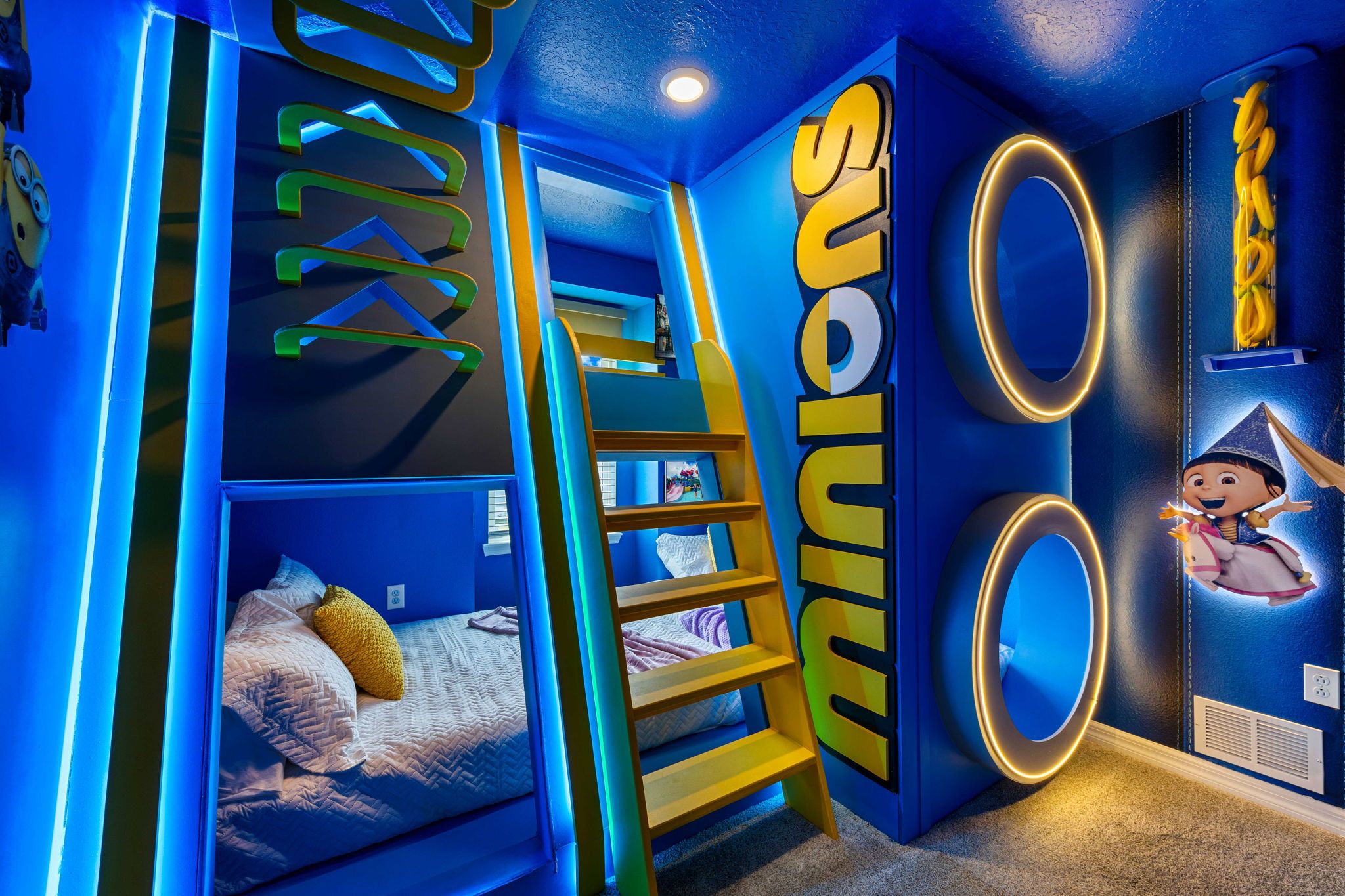 Una habitación con una cama litera, una escalera, un espejo grande y una pared con la palabra 'work' parcialmente visible.