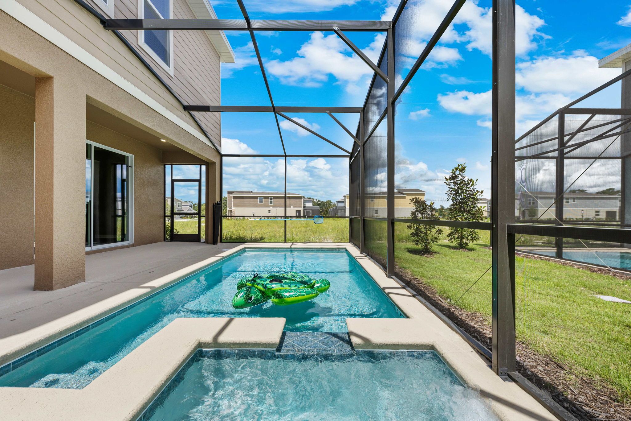 Piscina com hidromassagem, rodeada por um espaço coberto com grandes janelas.