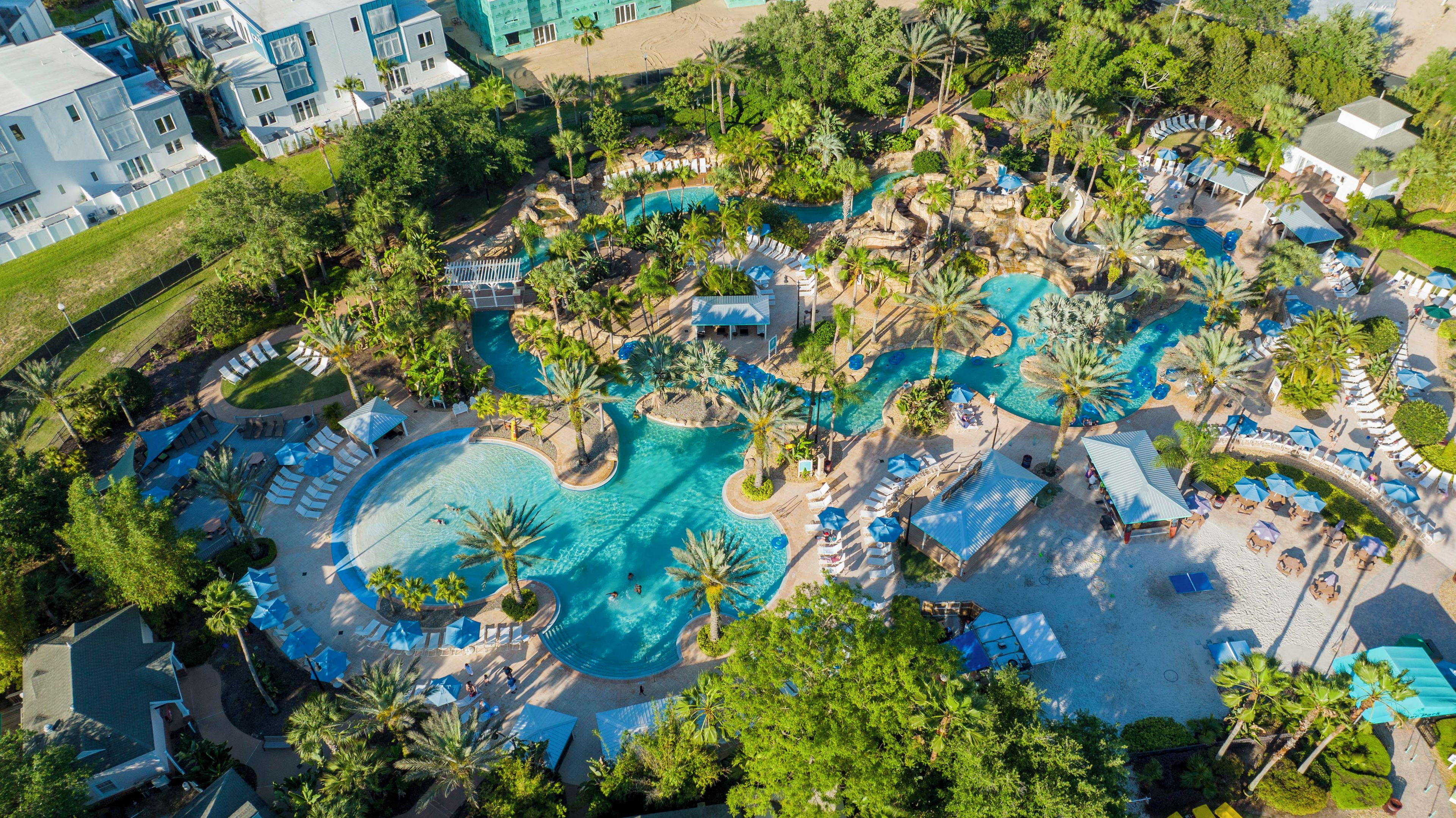 Vue aérienne d’un complexe hôtelier doté de plusieurs piscines, de palmiers et d’espaces de détente.