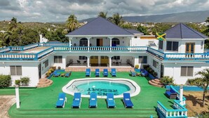 Un resort con piscina, varias sillas de descanso y vistas del paisaje circundante.