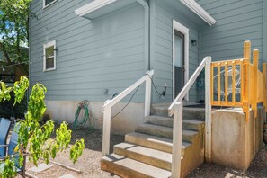 A residential building with a concrete staircase, a wooden handrail, and a door with a window. - East Austin 4-Bedroom Home, Private Backyard with Plunge Pool & BBQ, Sleeps 11 (Austin)