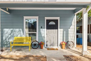 A house with a porch, a bench, a door, and two flower pots. - East Austin 4-Bedroom Home, Private Backyard with Plunge Pool & BBQ, Sleeps 11 (Austin)