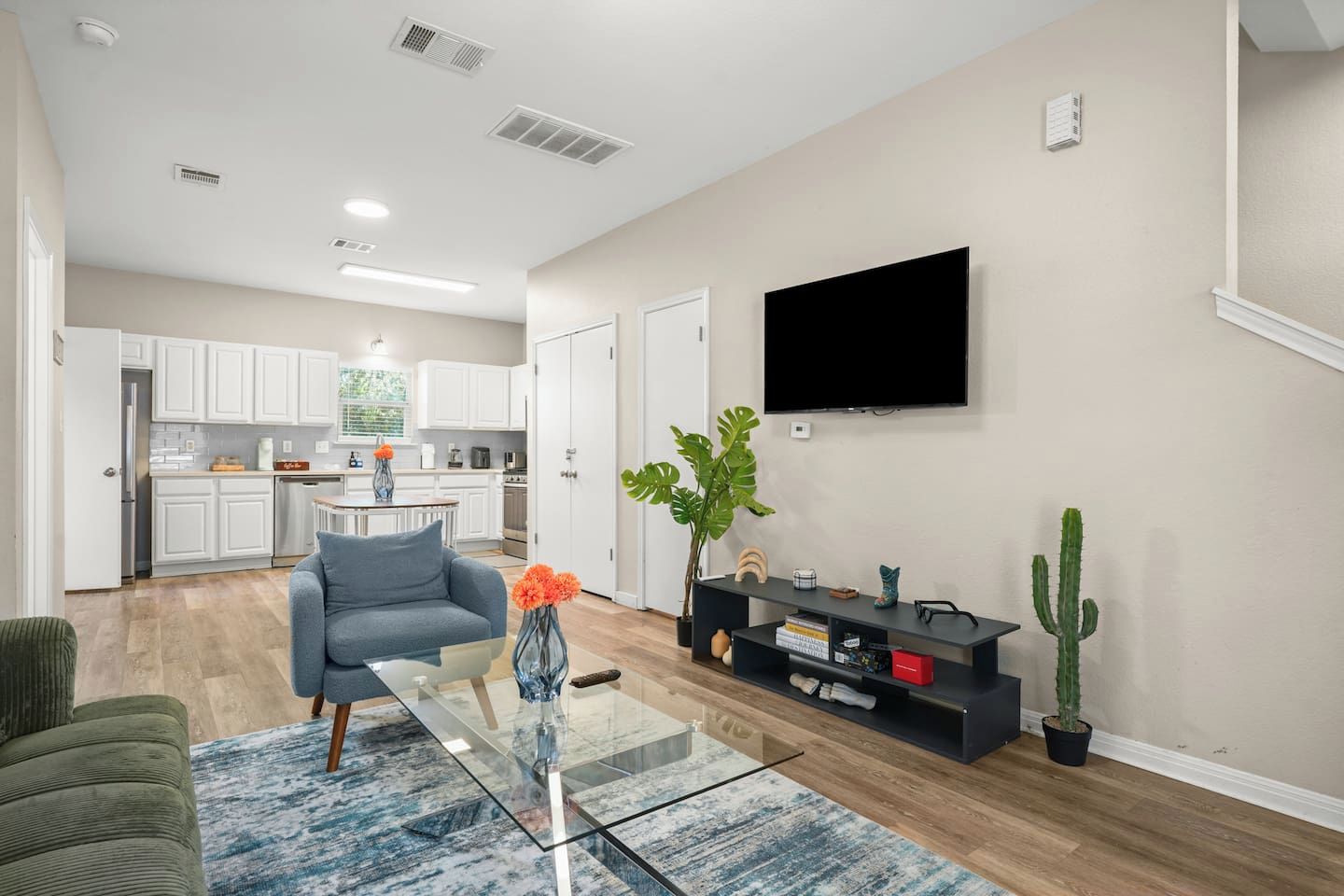 A modern living room with a sofa, coffee table, and a flat-screen TV mounted on the wall.