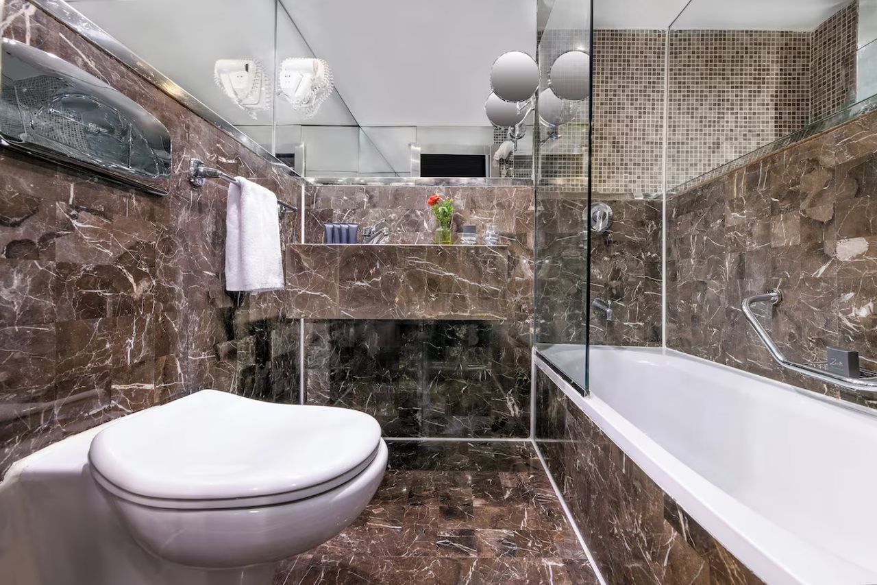 Ein modernes Badezimmer mit Marmorwaschbecken, Toilette und Badewanne.