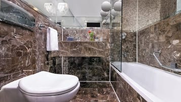 Une salle de bain moderne avec un lavabo en marbre, des toilettes et une baignoire.