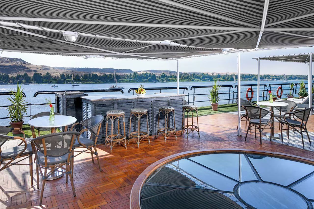 Ein überdachter Außenbereich mit Pool, Bar und Sitzgelegenheiten.