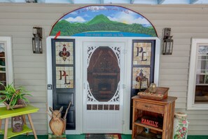 A house with a unique front door design, a welcome sign, and a decorative owl.