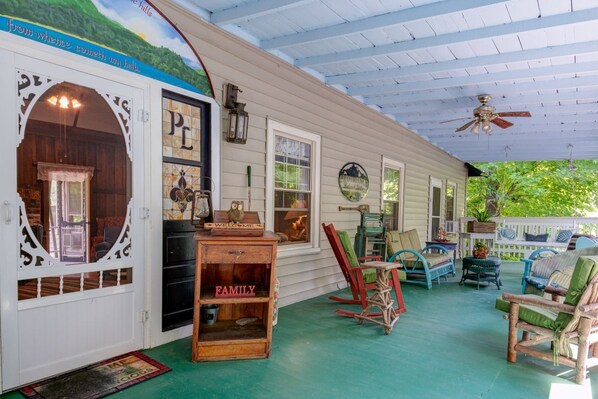 A porch with a covered area, a wooden table with a 'WELCOME' sign, and a 'FAMILY' sign.