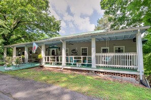 A two-story house with a porch, a flag, and a swan statue.
