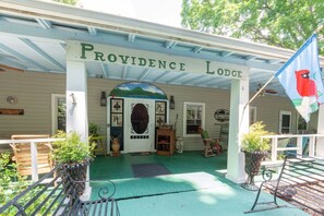 A building with a porch, a sign reading 'Providence Lodge,' and a flag with a bird.