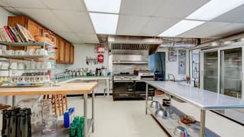 Une cuisine professionnelle équipée d’appareils en acier inoxydable, d’un grand four et d’un réfrigérateur.