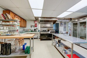 A commercial kitchen with stainless steel appliances, a large oven, and a refrigerator.
