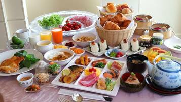 Variedad de opciones de desayuno, como pasteles, frutas y bebidas, dispuestas sobre una mesa.