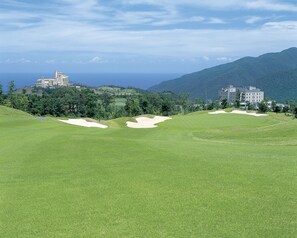 A golf course with bunkers and a large building in the background. - Grand Xiv Naruto the Lodge Inside Grand Xiv Naruto (Naruto)