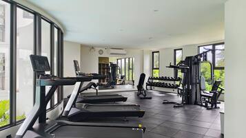 A gym with treadmills, dumbbells, and weight machines.