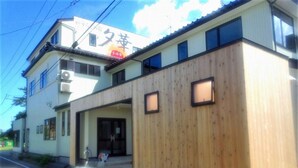 A two-story building with a traditional Japanese architectural style, featuring a wooden facade and a clear entrance.