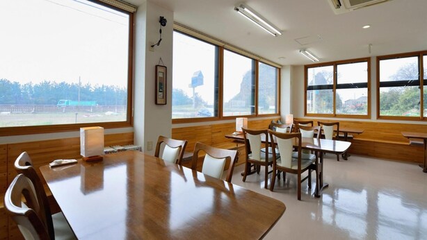 A conference room with a large table and chairs, large windows, and an air conditioning unit.