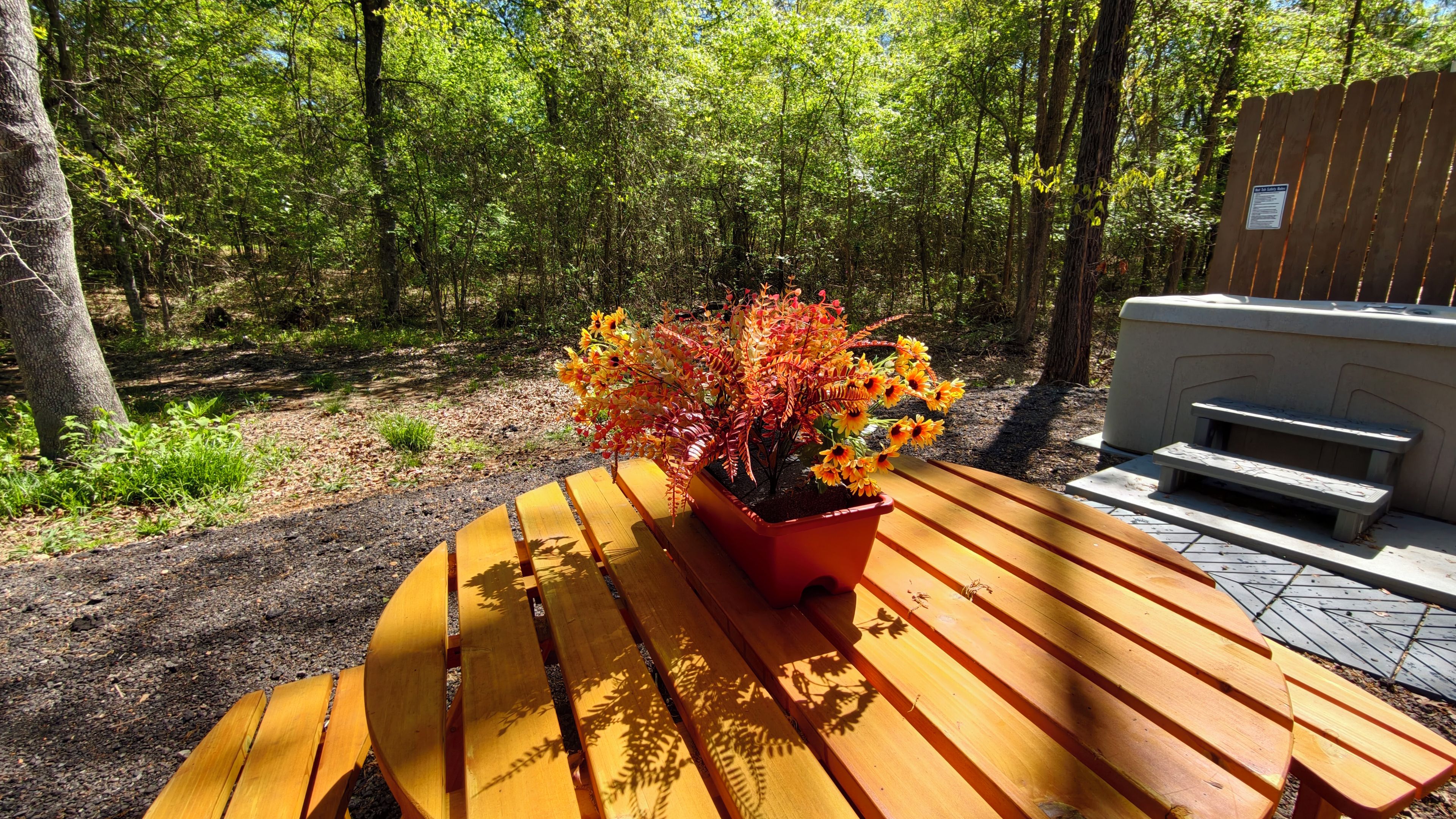 Una mesa de picnic de madera con un jardín de flores otoñales.
