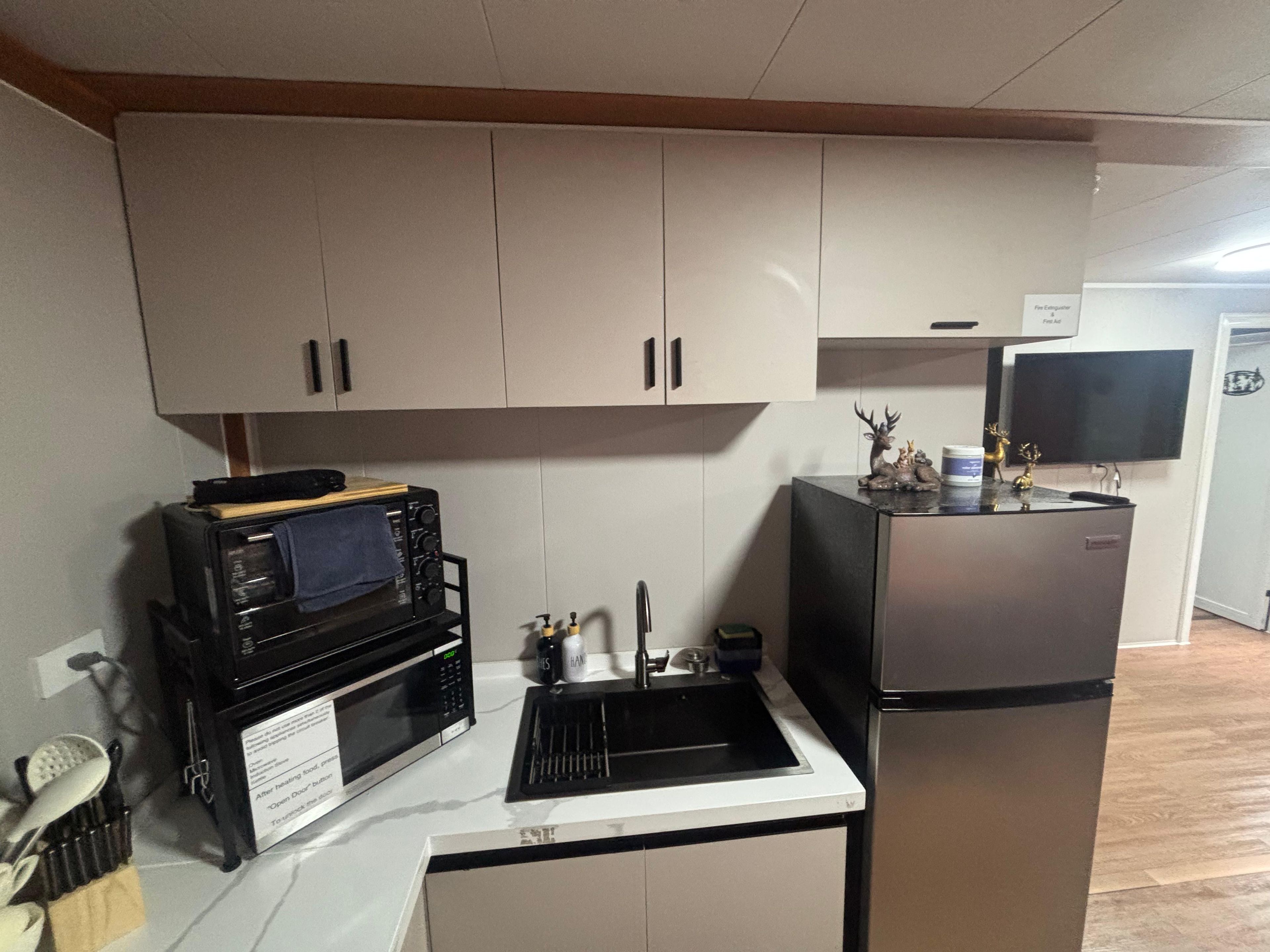 Una cocina compacta equipada con microondas, tostadora y refrigerador.