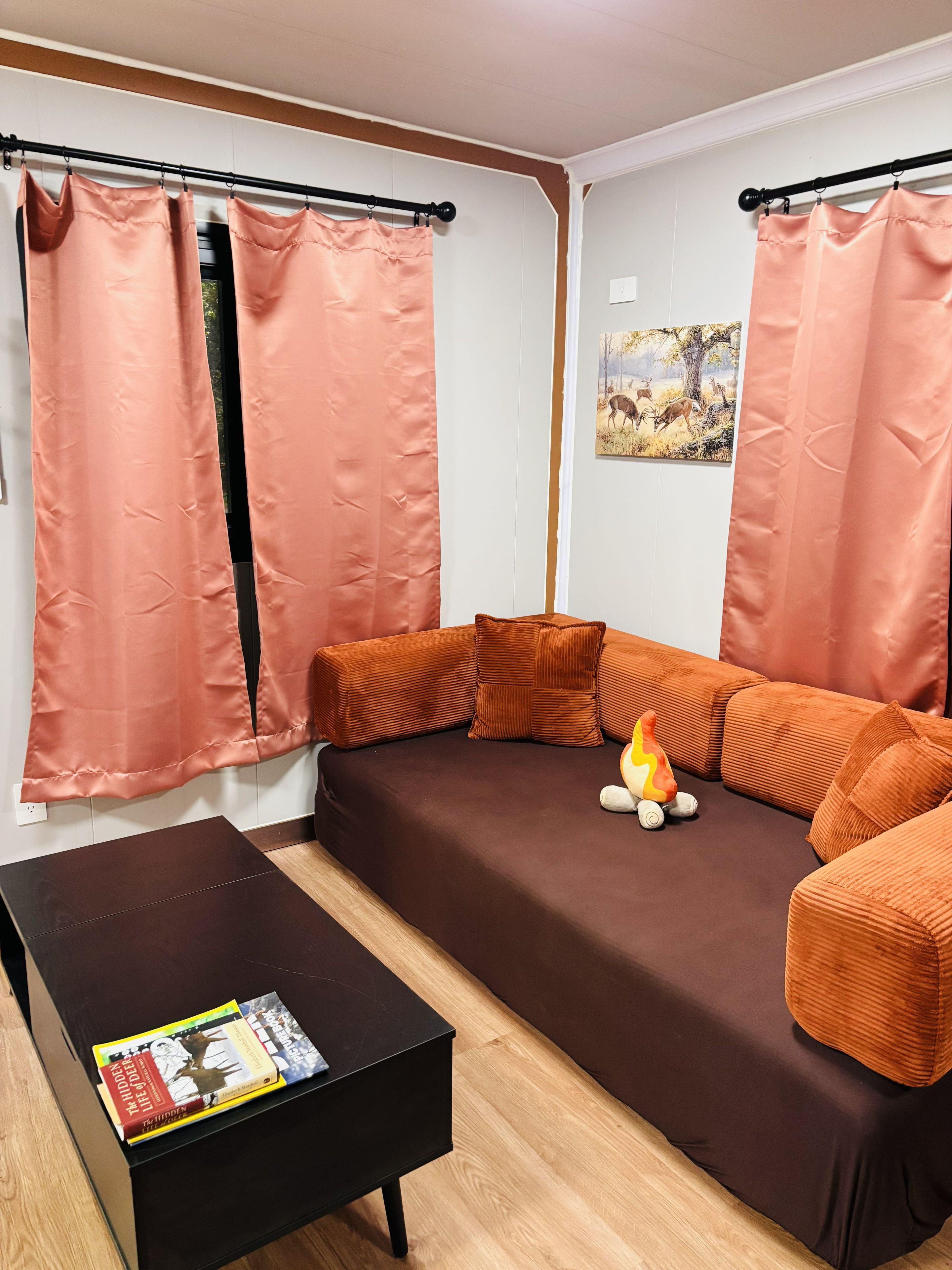 Una sala de estar con un sofá marrón, una mesa de centro negra y una chimenea.